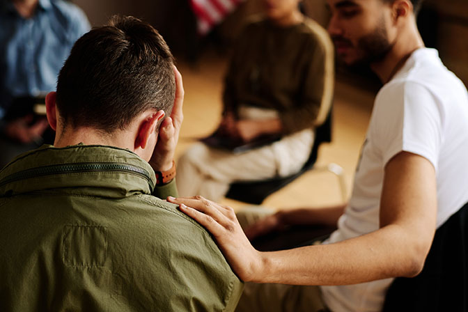 young adult comforting someone at a support group meeting