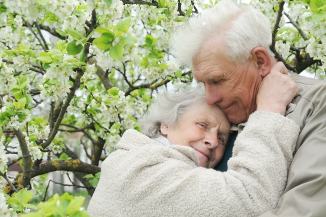 grandparents embracing in a garden