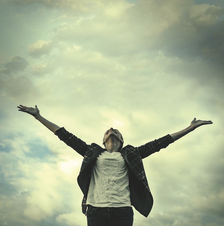 person holding their arms out to the sky